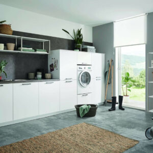 Küchenzeile (Weiß) mit dunkler Arbeitsplatte (Grau), offenen Hängeregalen und drei hohen Küchenschränken - der mittlere mit Waschmaschine