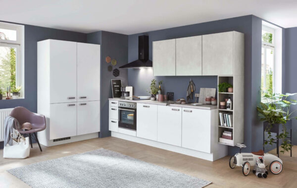Matt-weiße Küchenzeile mit separat stehendem hohen Küchenschränken. Komplettiert durch eine schwarze Dunstabzugshaube und hellgrauen Hängeschränken.