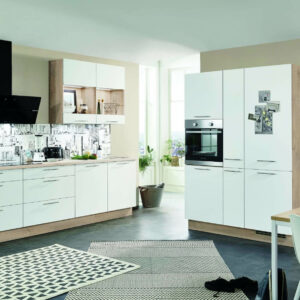 Weiße Küchenzeile mit matten Fronten und hellem Holzkorpus. Daneben eine hohe Küchenschrankwand mit eingebautem Backofen.